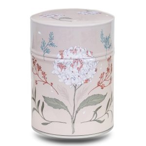 Metal tea caddy illustrated with a white flower on a beige background