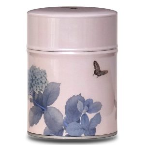 Metal tea caddy illustrated with pastel flowers on a pink-beige background