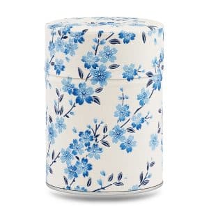 Boîte à thé artisanale Hidaka 100 g, recouverte de papier washi ivoire décoré de branches de cerisier bleu clair et baies bleues, couvercle assorti décoré.